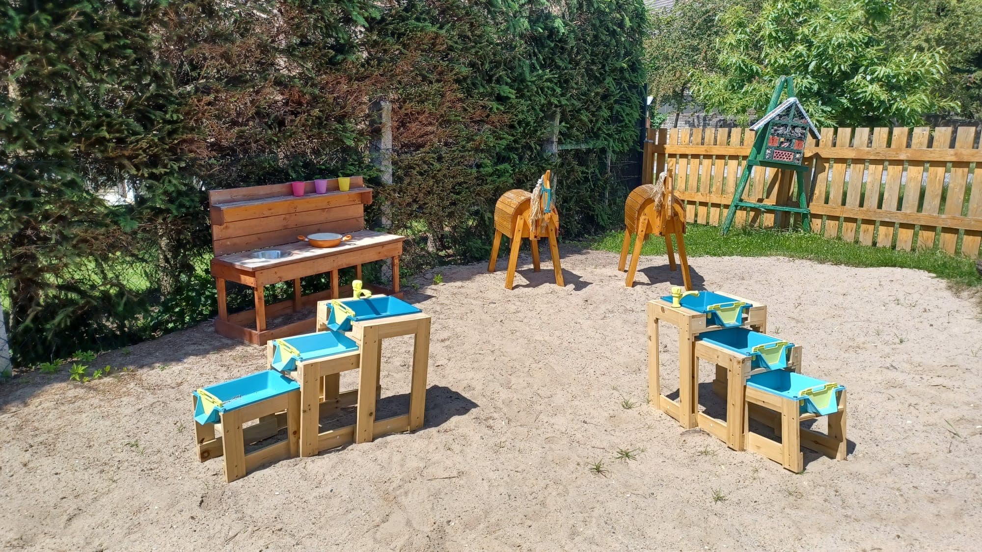 Holzpferde und Hocker für die Kinder im Sandbereich