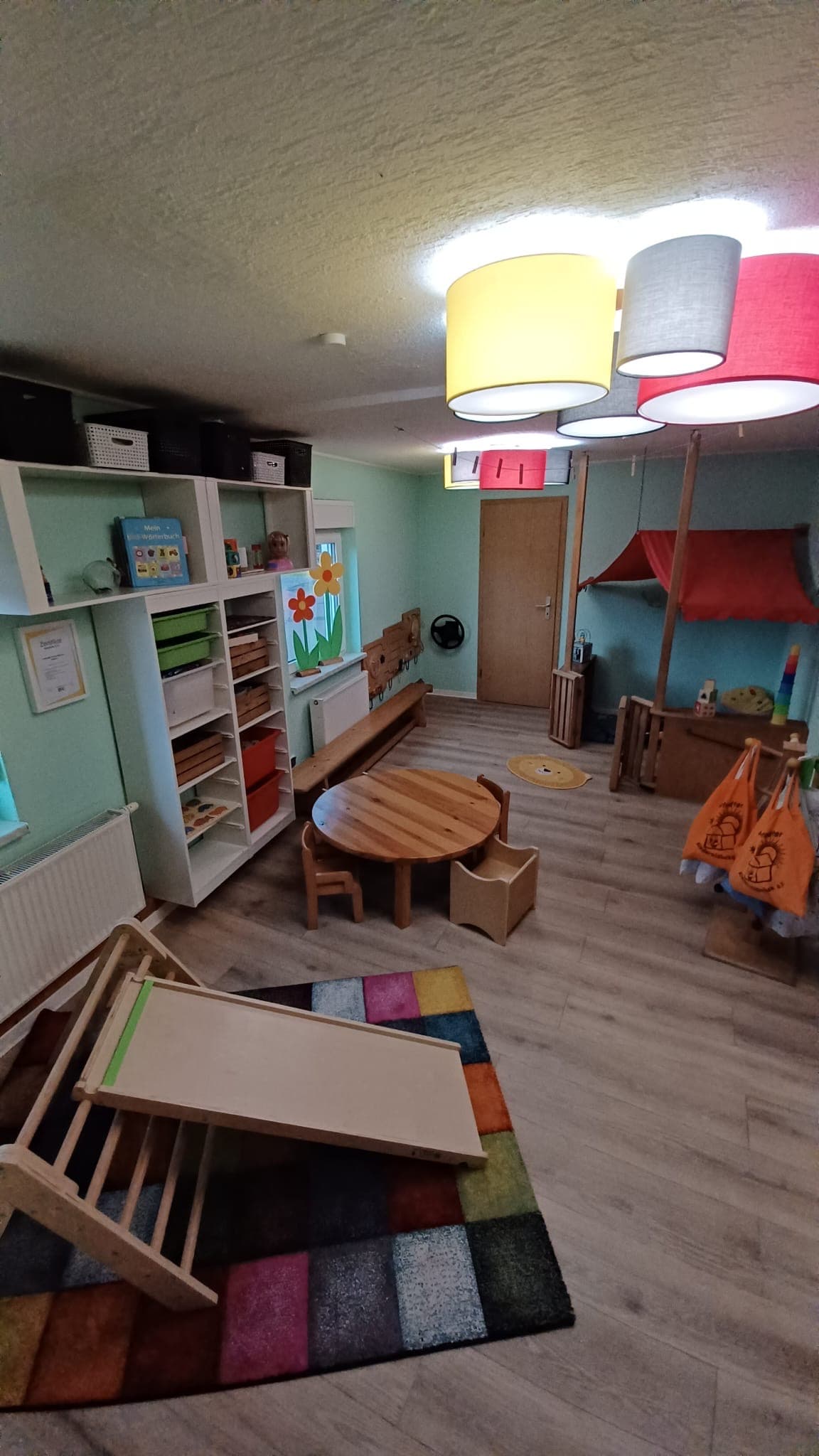 Helle Lampen über dem Spieltisch im Gruppenraum